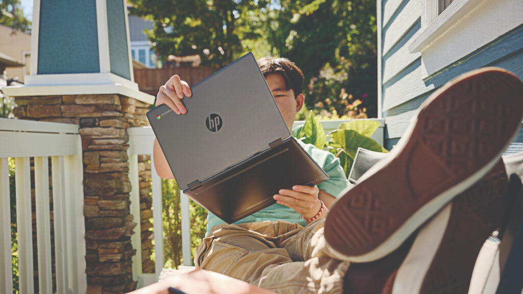 college student holding an HP Chromebook