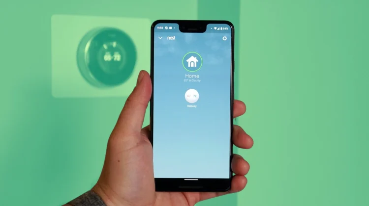 Hand holding phone with Nest app running