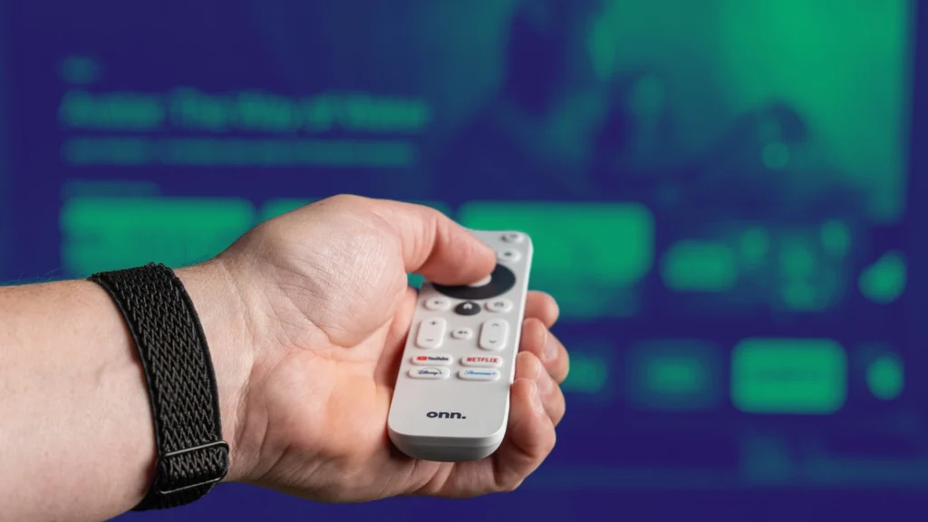 Onn. Walmart streaming remote in hand pointing at TV